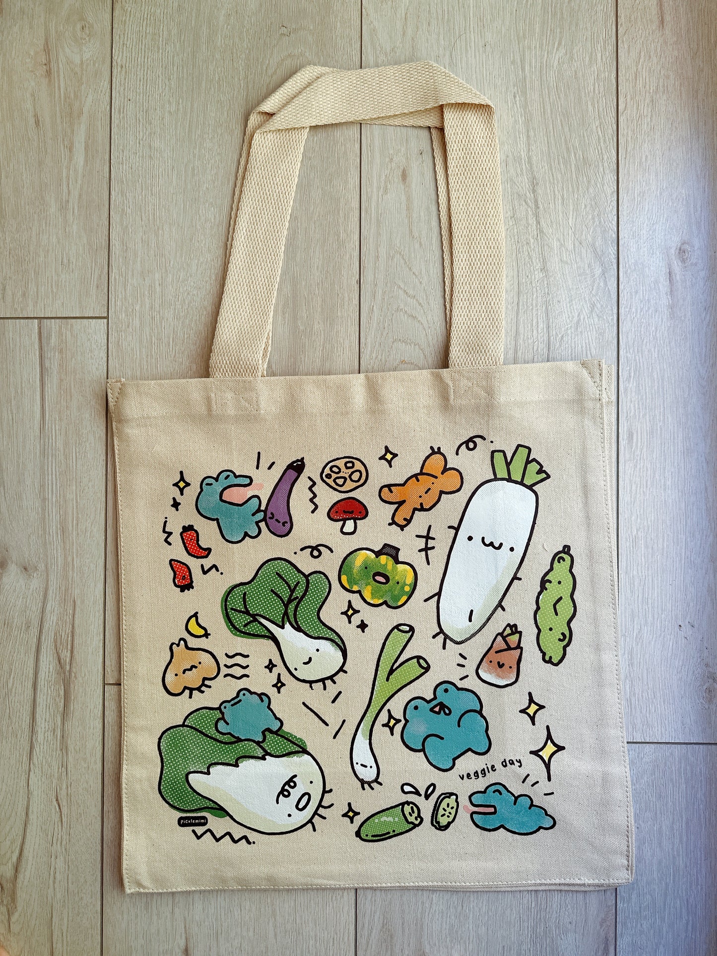 Tote bag with cartoon vegetable design on a wooden surface