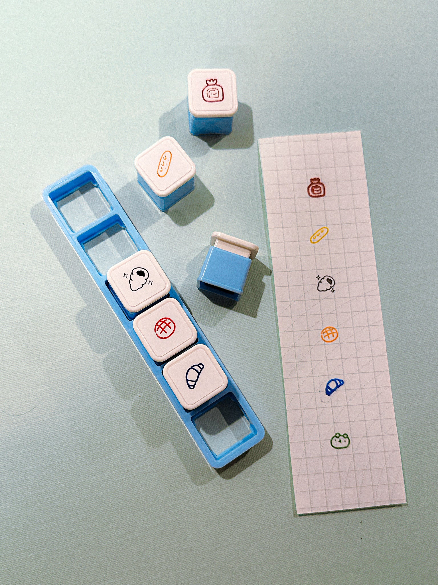 Set of colorful stamps with a blue holder on a light gray background