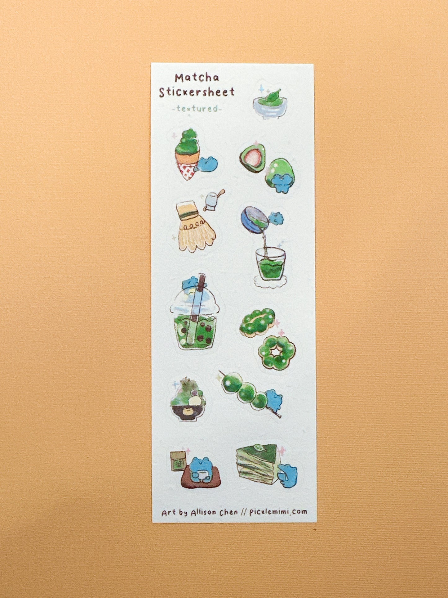 Sheet of matcha-themed stickers on a textured beige background